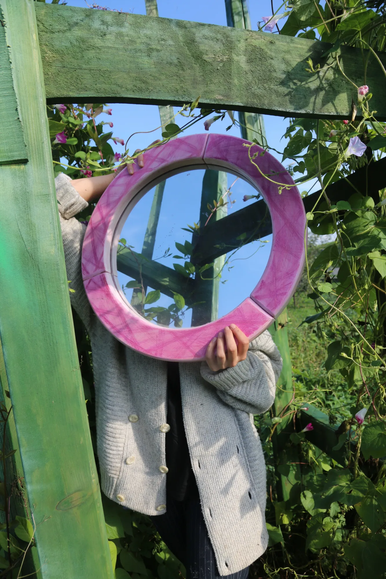 Lustro w drewnianej różowej ramie.